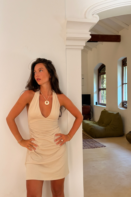 A halter-neck mini dress in a sustainable bamboo cotton stretch mix. Fitted through the torso with ruching at the waist to shape.