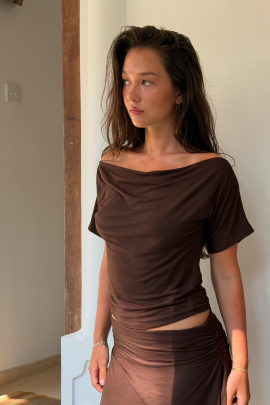 A short-sleeved blouse with flattering off-shoulder shaping across the shoulders.