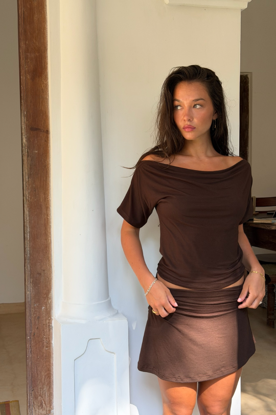 A short-sleeved blouse with flattering off-shoulder shaping across the shoulders.