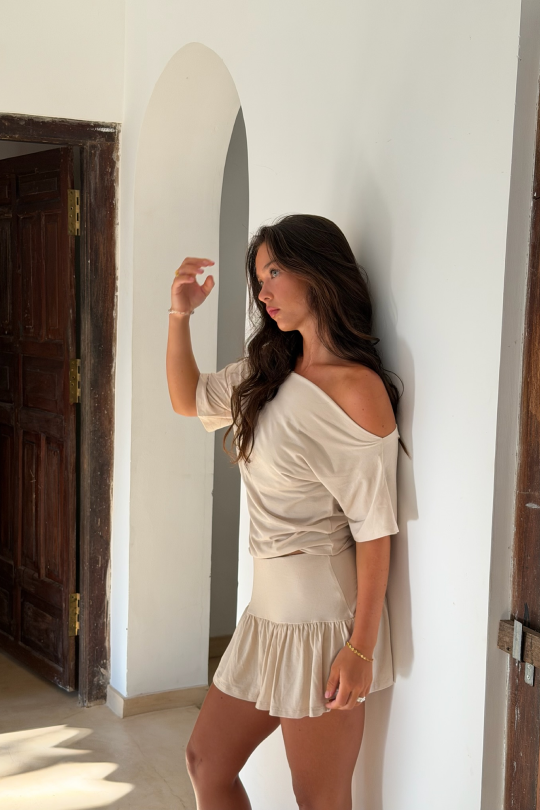 A short-sleeved blouse with flattering off-shoulder shaping across the shoulders.