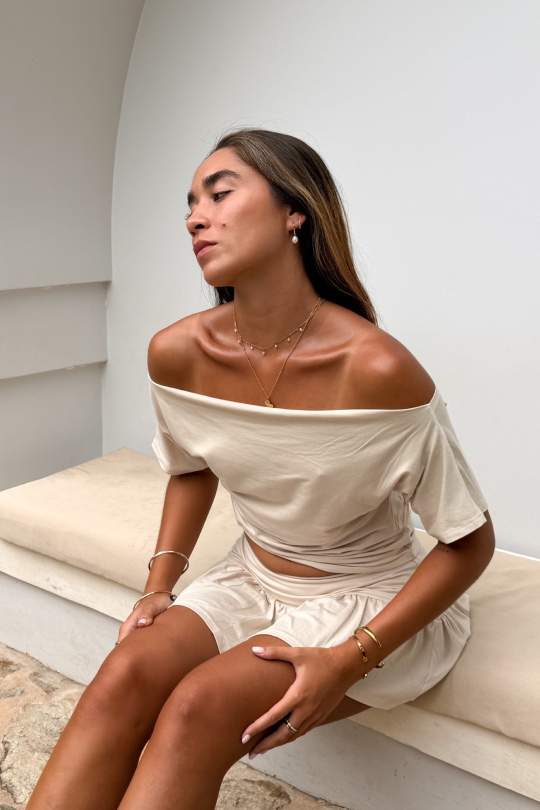 A short-sleeved blouse with flattering off-shoulder shaping across the shoulders.